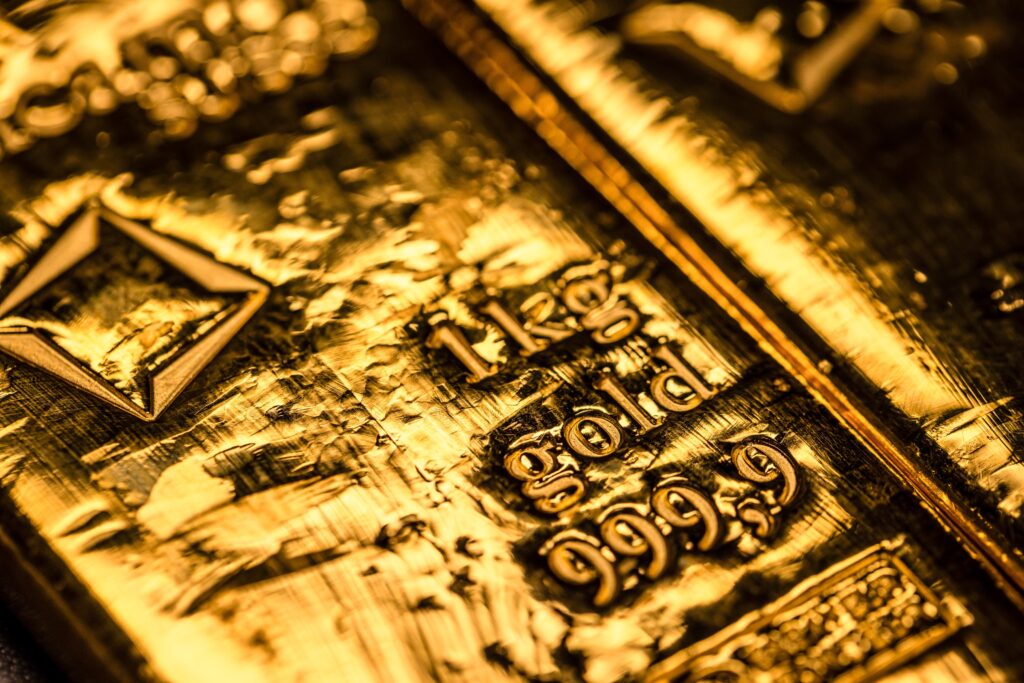 Ouro recua com menor demanda por ativos seguros, mas se mantém perto de recorde